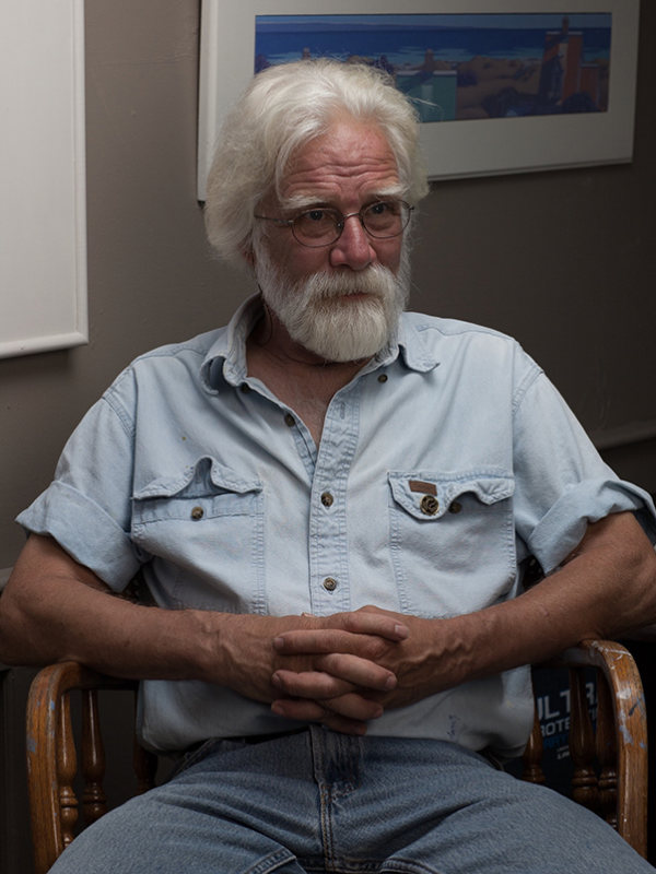 Peter Coes seated in his studio